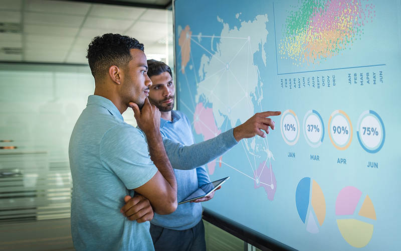 Two people looking at a world map