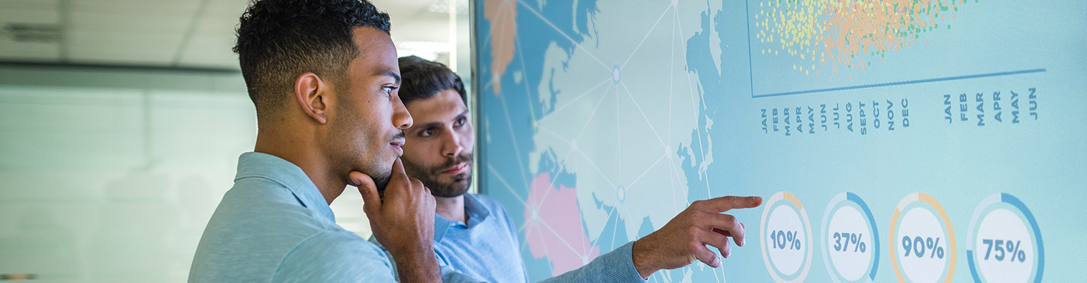 Two men looking at a map of the world with data